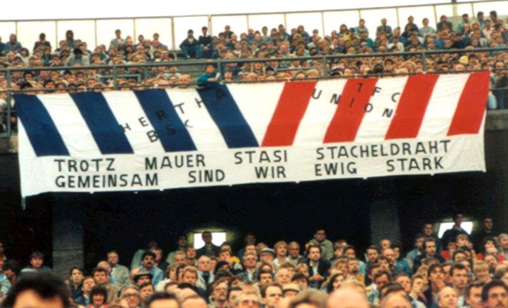 Im West-Berliner Olympiastadion wird in den 1980er Jahren ein Transparent gezeigt, dass die Fanfreundschaft zwischen Anhängern von Hertha BSC und dem 1. FC Union über die Mauer hinweg feiert. Bild: Wolfgang Weber