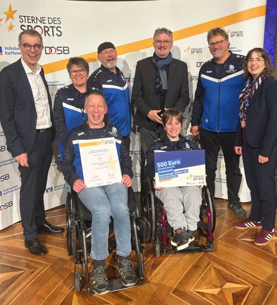 Der Vorsitzende des Sportkreises Darmstadt-Dieburg, Rafael Reißer (stehend, vierter von links) freut sich mit dem VSG Darmstadt 1949 und den Volksbankvertretern.    Bild: SKDADI