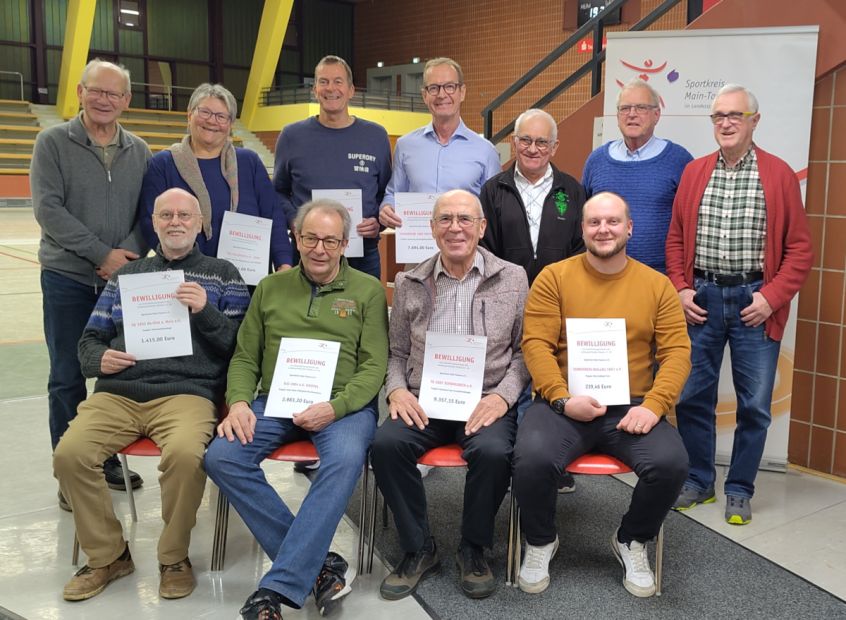 Anfang des neuen Jahres 2026 in großer Runde bei den Vereinsgesprächen in der Kreissporthalle des Main-Taunus-Kreises: Sportkreisvorsitzender Hans Böhl (hinten links) und Sportkreisvorstand Richard Grützner (hinten rechts) mit Vertreterinnen und Vertretern der Sportvereine Turn- und Sportgemeinde Sulzbach, Tennis Westerbach Eschborn, Turnverein Hofheim, Schützengesellschaft Okriftel, Turnverein Wallau, Schützengesellschaft Okriftel, Turn- und Sportverein Kriftel, Turngemeinde Schwalbach. Bild: Marion Polydore