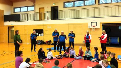 Kinder der Astrid-Lindgren-Schule und das Prüferteam bei der Einstimmung auf die gleich folgenden Aufgaben.                Bild: Manfred Schmidt