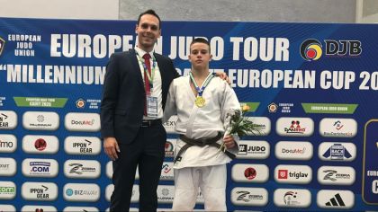 Man sieht Dimitro Matuzny mit seinem Landestrainer und der Goldmedaille