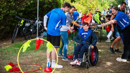 Rolli-Fahrer fährt durch dekorierte halbe Gymnastikreifen.