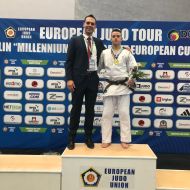 Man sieht Dimitro Matuzny mit seinem Landestrainer und der Goldmedaille